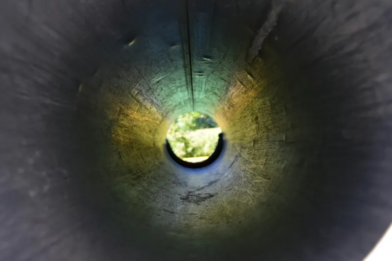 Looking down the inside of a drain pipe towards daylight