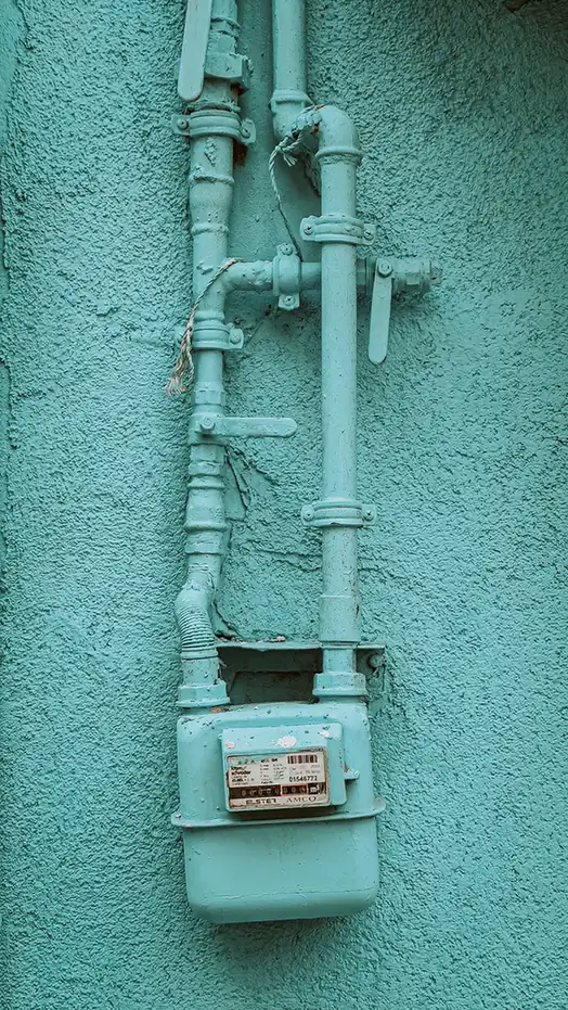 Gas pipework and valves fixed to a painted outside wall