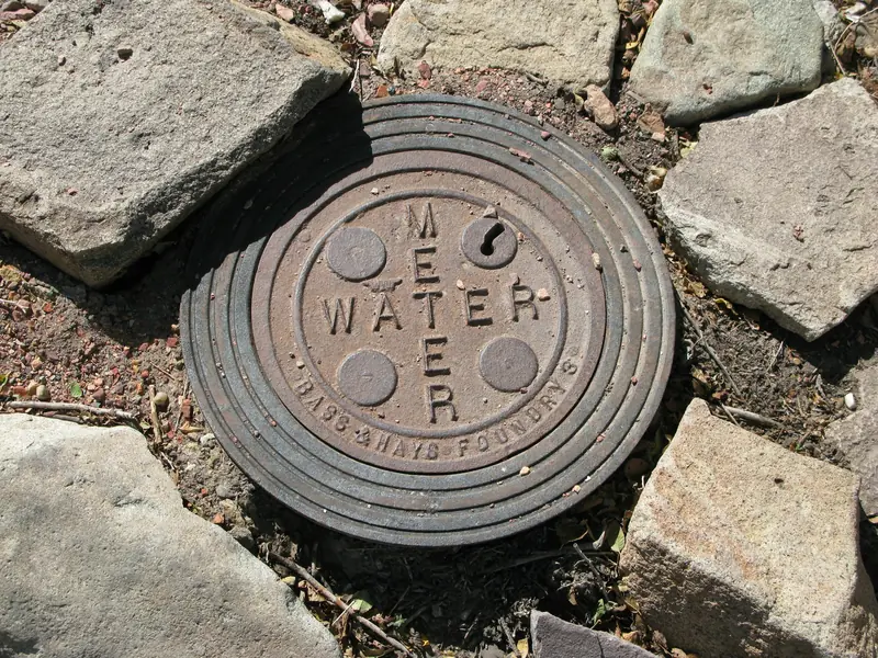 A municipal water meter and stopcock set in the ground at a property boundary